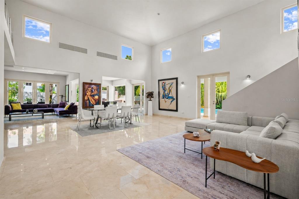 A spacious, high-ceilinged living and dining area features white walls, tile floors, and modern furniture — Sabanera Dorado CAMINO DEL FLAMBOYAN STREET UNIT 247, DORADO, PR