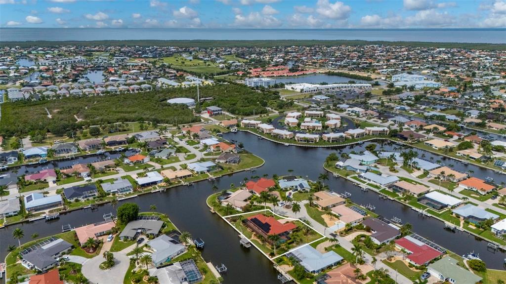 A single-story house with a red tile roof, orange garage door, and palm trees — 950 LASSINO COURT, PUNTA GORDA, FL