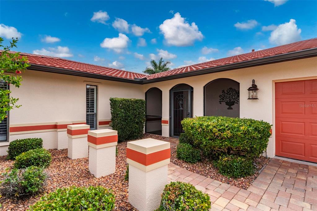 A bright living area with tile floors, a ceiling fan, and sliding glass doors to a patio — 950 LASSINO COURT, PUNTA GORDA, FL