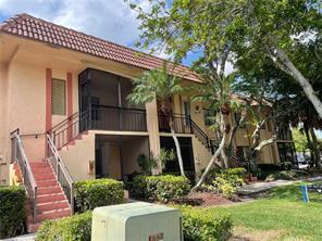 A two-story peach-colored apartment building features exterior staircases, screened balconies, and a tile roof — 158 Lakeview Drive, Weston FL 33326, WESTON, FL