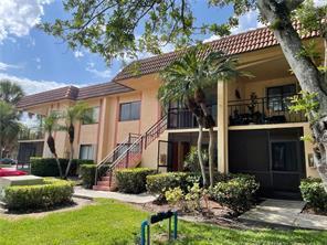 A two-story apartment building with a staircase, balconies, and palm trees on a sunny day — 158 Lakeview Drive, Weston FL 33326, WESTON, FL