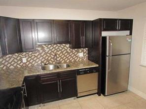 A kitchen features dark wood cabinets, granite countertops, a tiled backsplash, and stainless steel appliances — 158 Lakeview Drive, Weston FL 33326, WESTON, FL