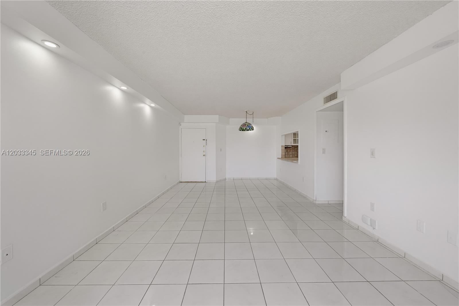 A bright, empty room features white walls, white tiled floors, and recessed ceiling lighting — 8050 NW 8th St # 110, Miami FL 33126, MIAMI, FL