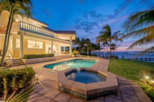 A two-story house with a pool, hot tub, and palm trees overlooking a bay at sunset — 901 SE Riverside Drive, Stuart FL 34994, STUART, FL