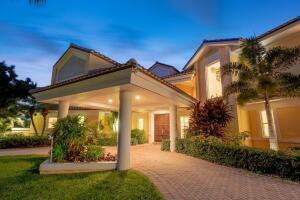 A large house with a covered entryway and a paved driveway at twilight — 901 SE Riverside Drive, Stuart FL 34994, STUART, FL