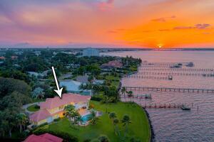 An aerial view of a waterfront house with a pool at sunset — 901 SE Riverside Drive, Stuart FL 34994, STUART, FL