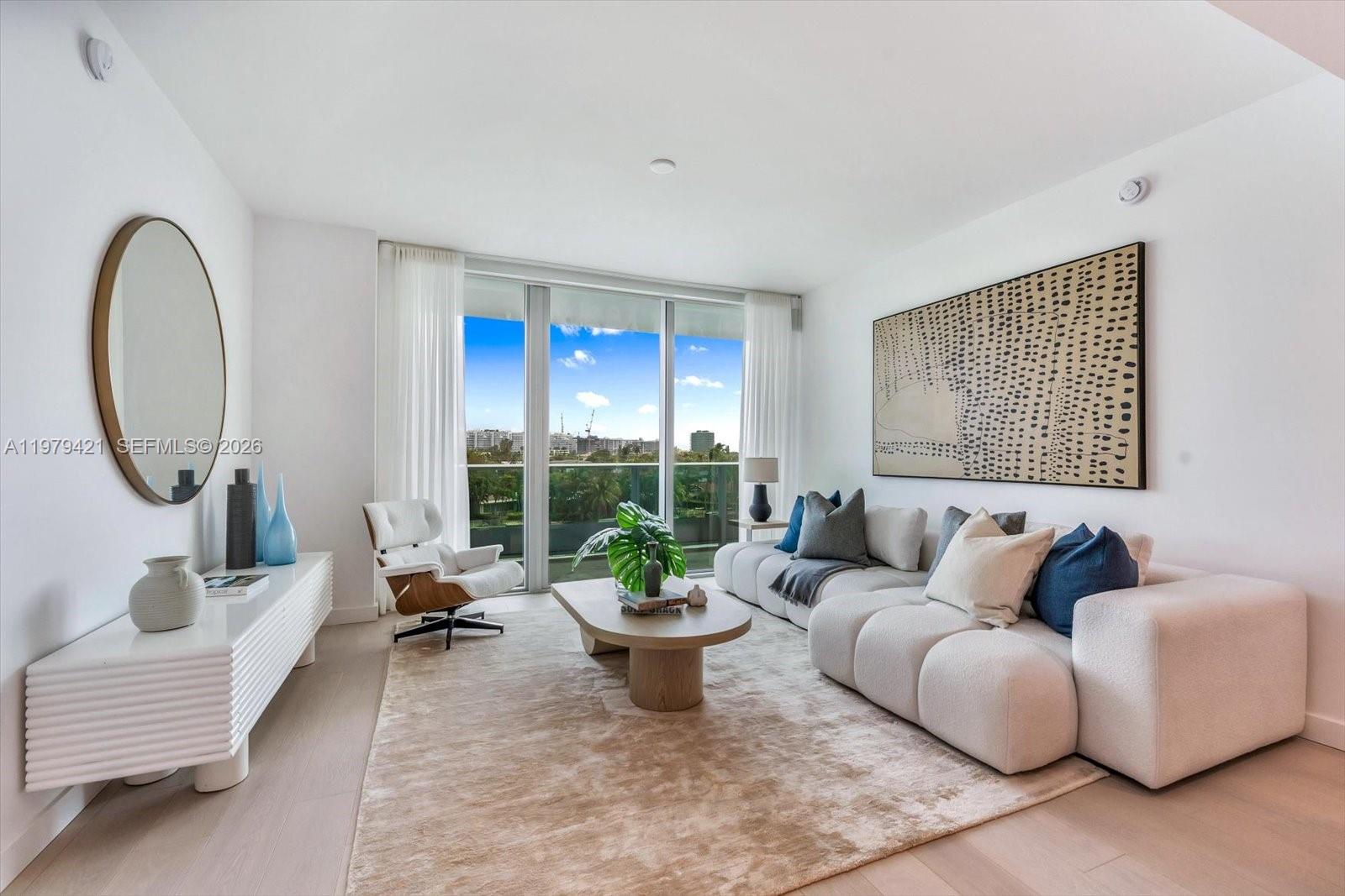 A modern living room features a white sectional sofa, a coffee table, and floor-to-ceiling windows — 9201 E Bay Harbor Dr # 503, Bal Harbour FL 33154, BAL HARBOUR, FL