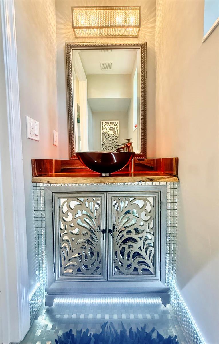 A powder room features a live-edge wood countertop, vessel sink, and mirrored vanity cabinet — 1015 Ventnor Avenue # 3a, Delray Beach FL 33444, DELRAY BEACH, FL