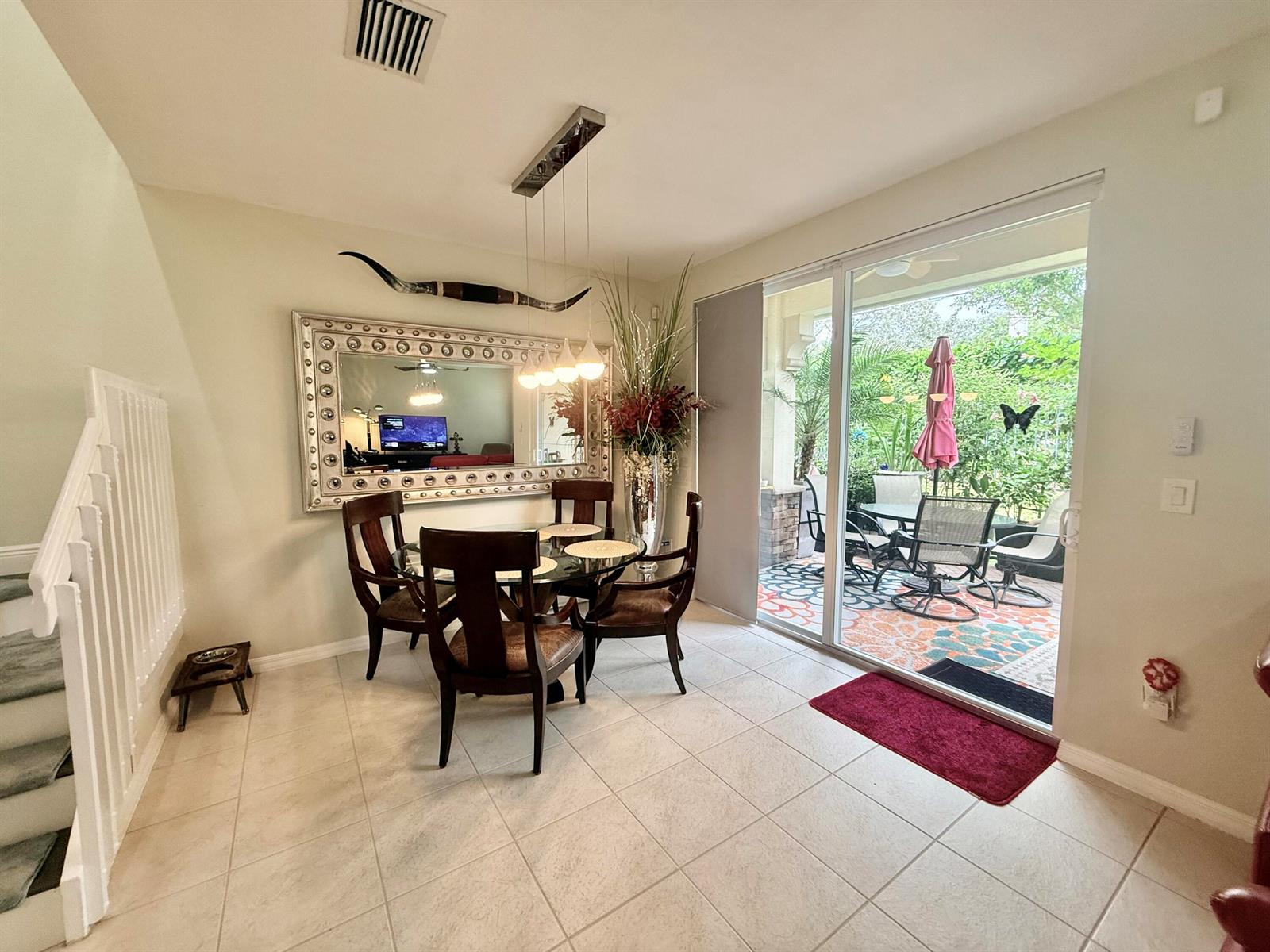 A dining area features a glass table, four chairs, a large mirror, and sliding glass doors — 1015 Ventnor Avenue # 3a, Delray Beach FL 33444, DELRAY BEACH, FL