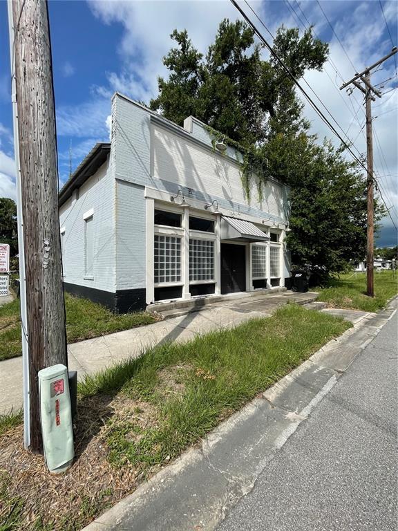 A light blue, single-story brick commercial building with glass block windows and a metal awning — 55 GUERRANT STREET, UMATILLA, FL