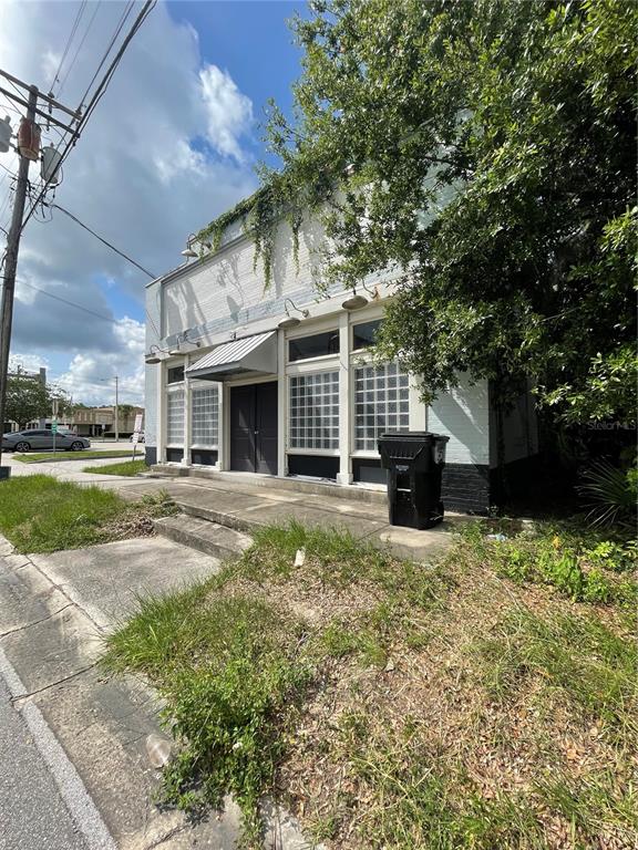 A white brick commercial building with glass block windows and a metal awning — 55 GUERRANT STREET, UMATILLA, FL