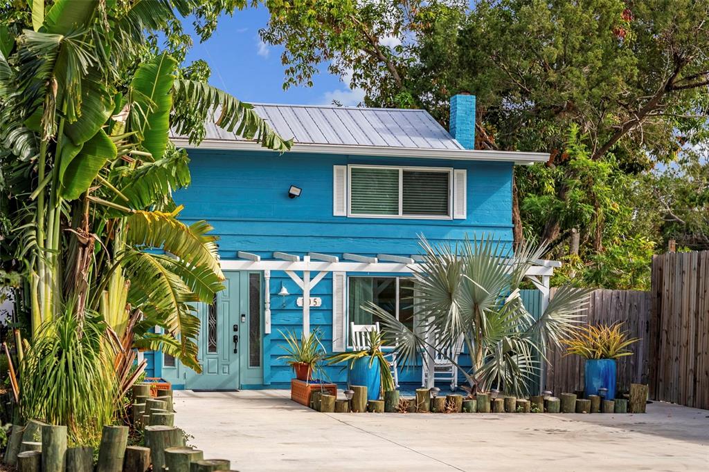 A two-story blue house with a metal roof, white trim, and a concrete driveway — 105 TUCKER AVENUE, SARASOTA, FL