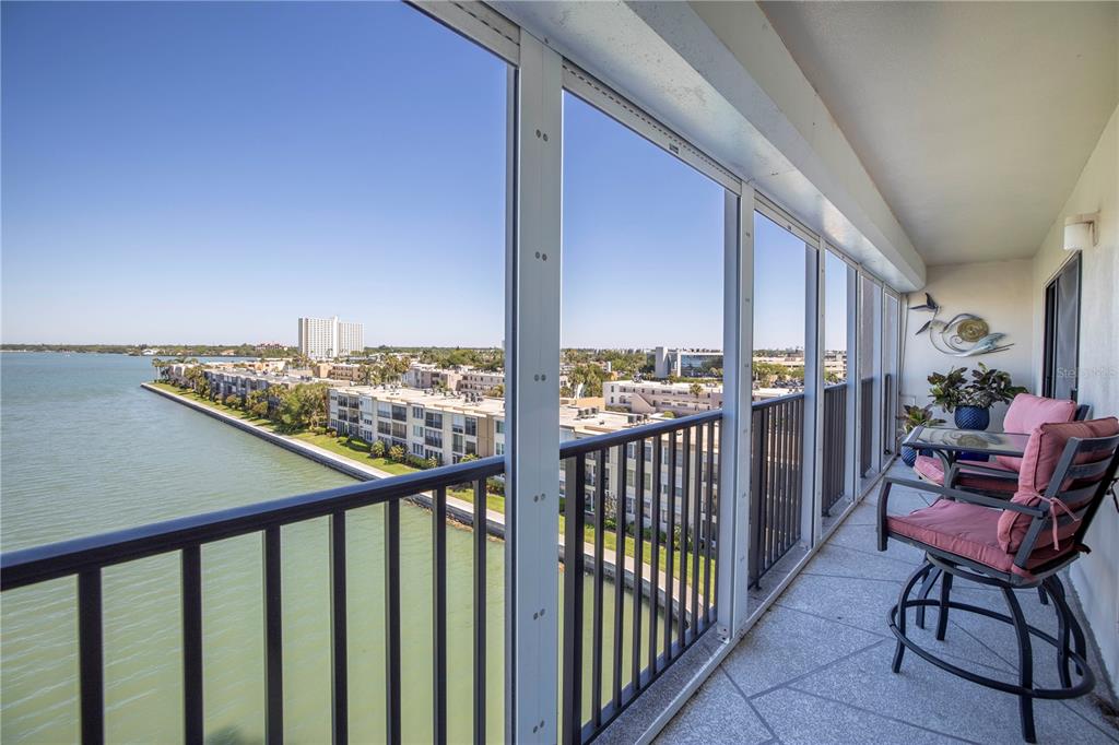A balcony with a black metal railing overlooks a body of water and coastal buildings — 7300 SUN ISLAND DRIVE S UNIT 602, SOUTH PASADENA, FL