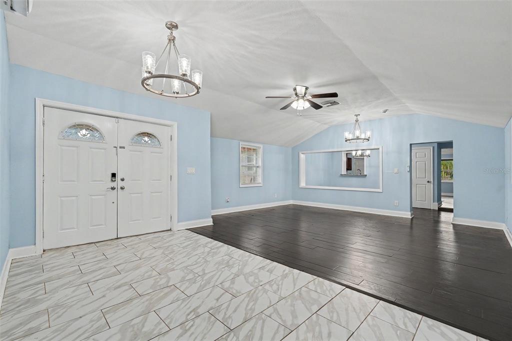 A living room features light blue walls, a vaulted ceiling, and mixed tile and wood flooring — 9220 MCINTOSH ROAD, DOVER, FL