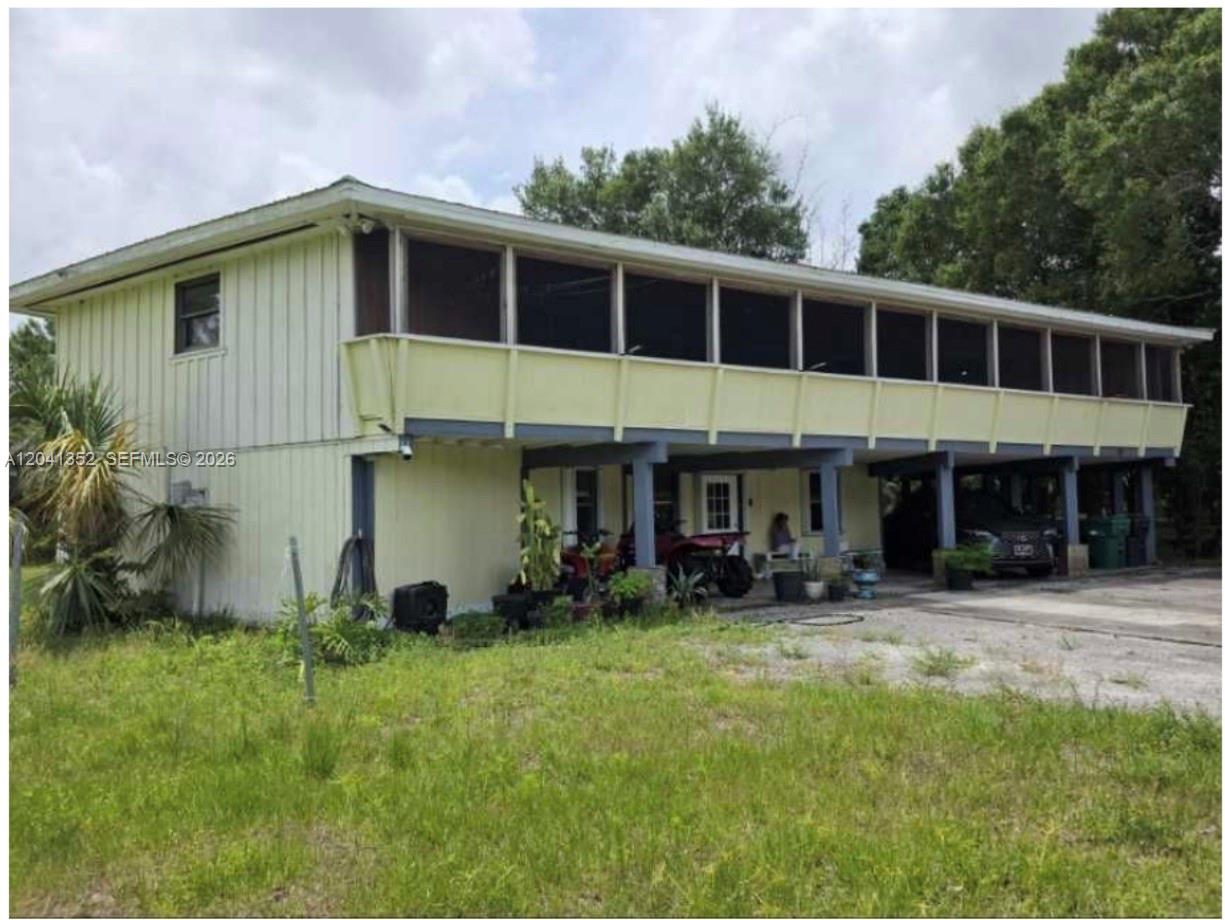 A two-story house with a screened-in upper balcony and a covered ground-level carport area — 10337 NE 120TH, Okeechobee FL 34972, OKEECHOBEE, FL