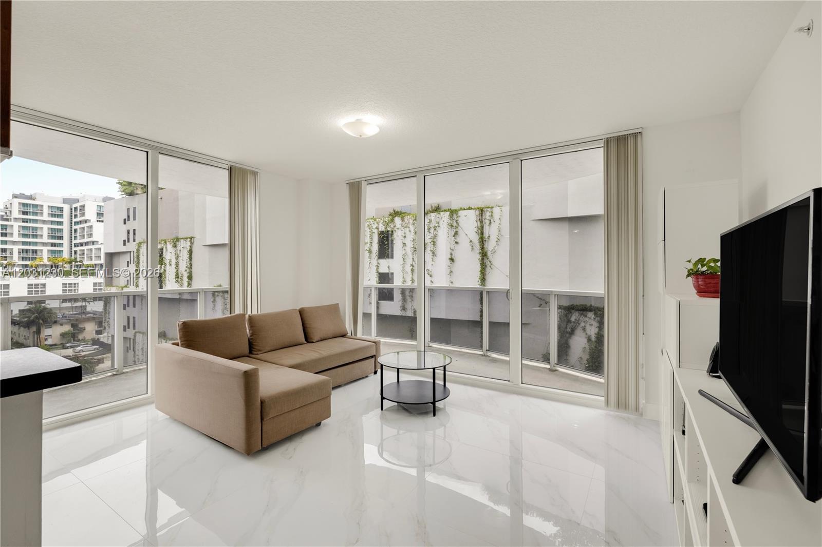 A living room features white marble floors, a beige sofa, and a glass coffee table — 601 NE 23rd St # 706, Miami FL 33137, MIAMI, FL