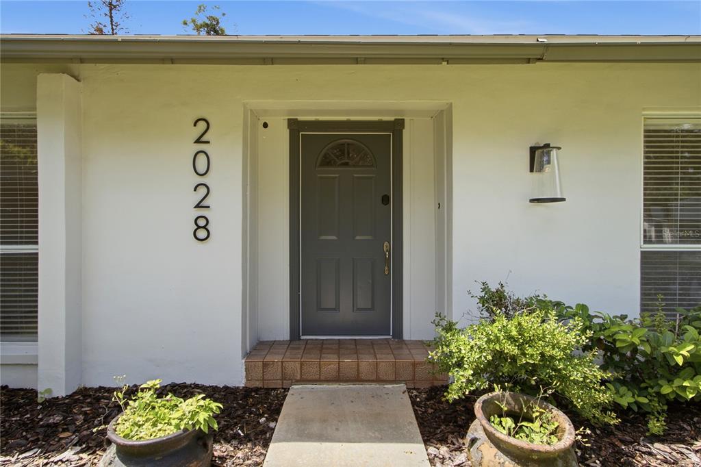 A front exterior view shows a gray door with a house number on the wall — 2028 SUSSEX ROAD, WINTER PARK, FL