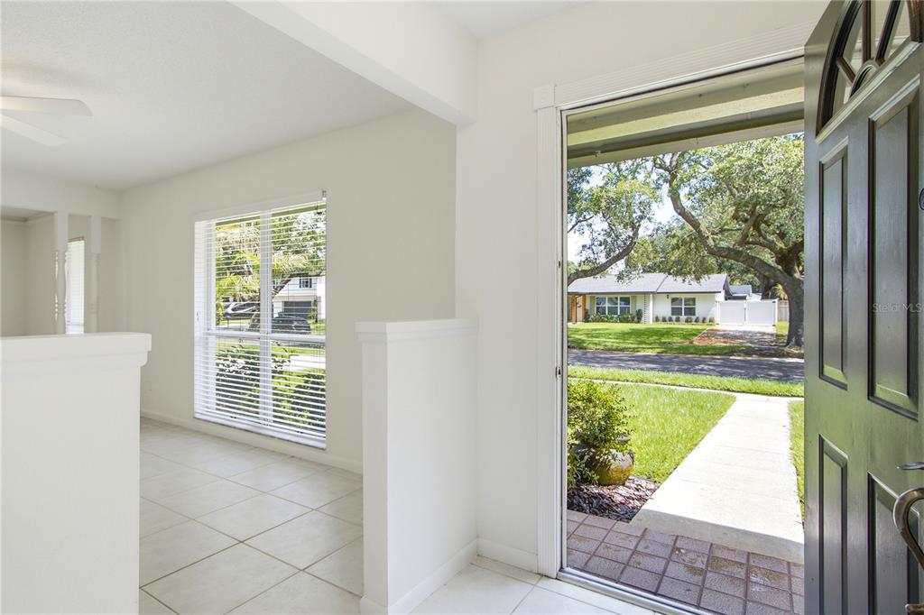 An open entryway with tile flooring leads to a living area and an open front door — 2028 SUSSEX ROAD, WINTER PARK, FL