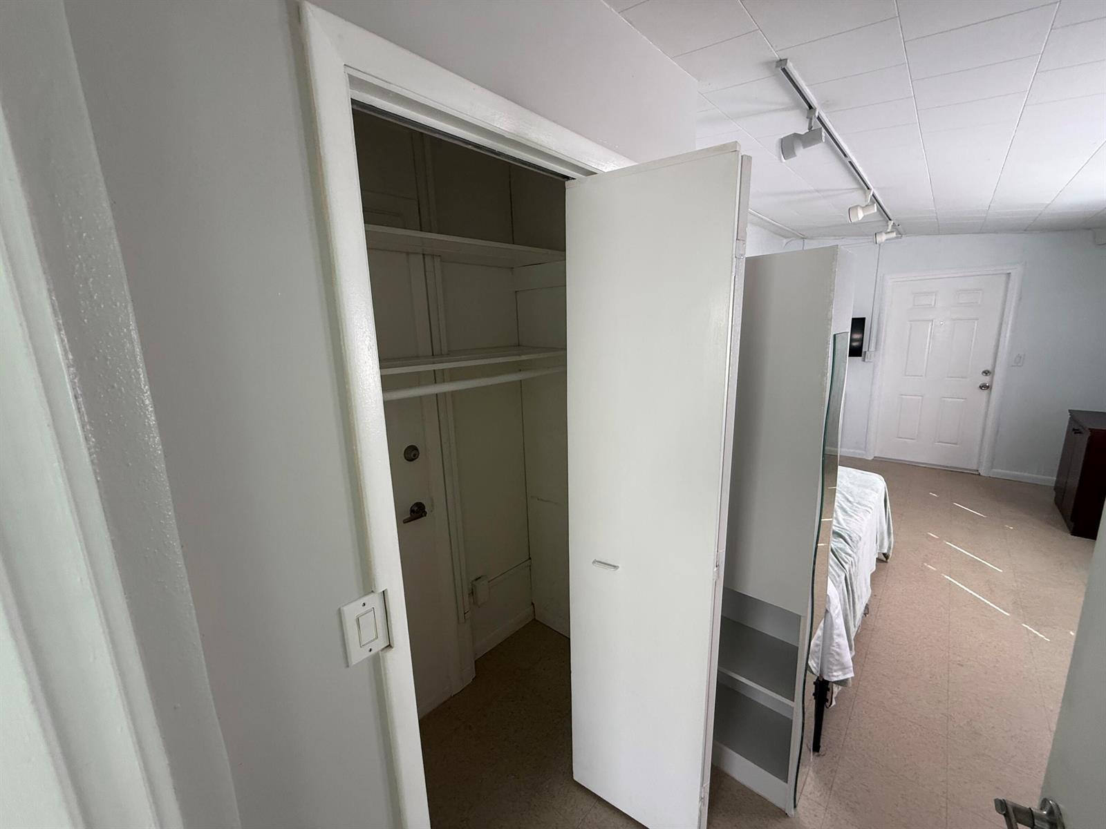 An open closet with shelves and a hanging rod is visible next to a bedroom — 605 E Coast Avenue # 2, Lantana FL 33462, LANTANA, FL