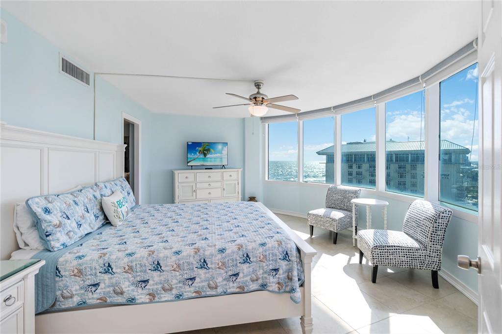 A bedroom with a king bed, two patterned chairs, and large windows overlooking the ocean — 2625 SOUTH ATLANTIC AVENUE UNIT 12BSW, DAYTONA BEACH SHORES, FL