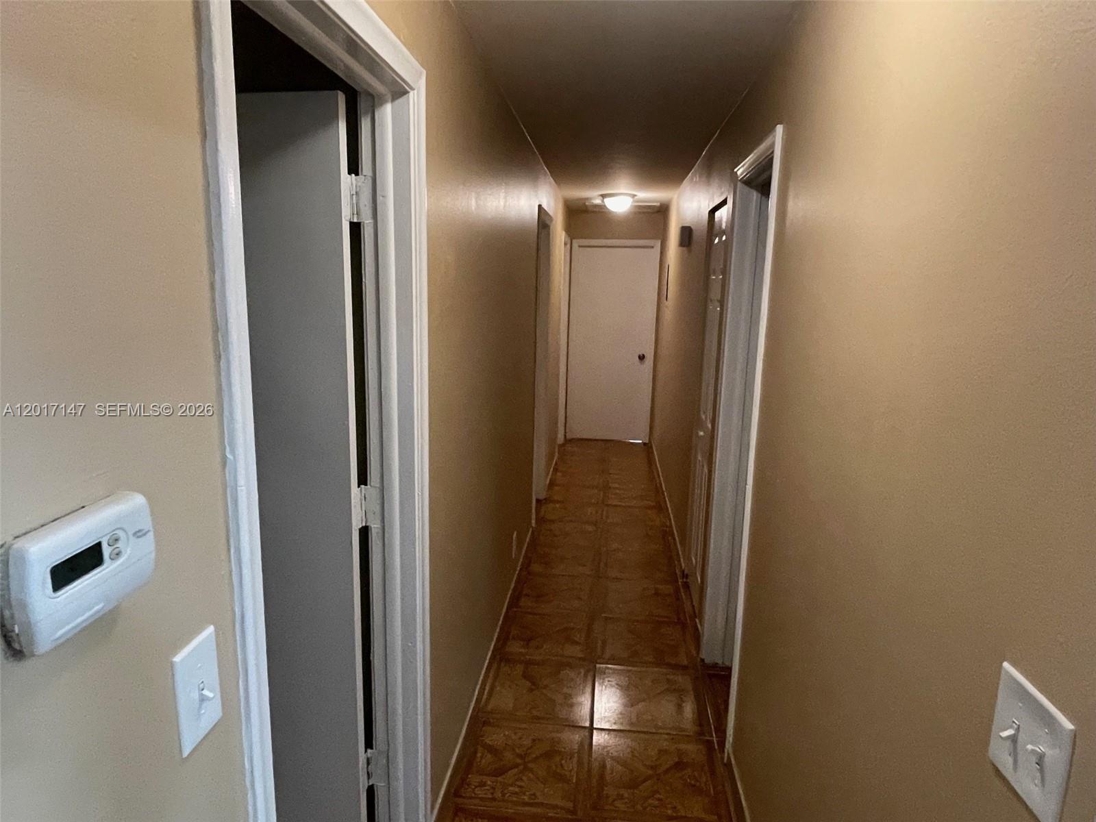 A narrow hallway features tan walls, tiled flooring, and multiple white interior doors — 5960 NW 20th St # 5960, Lauderhill FL 33313, LAUDERHILL, FL