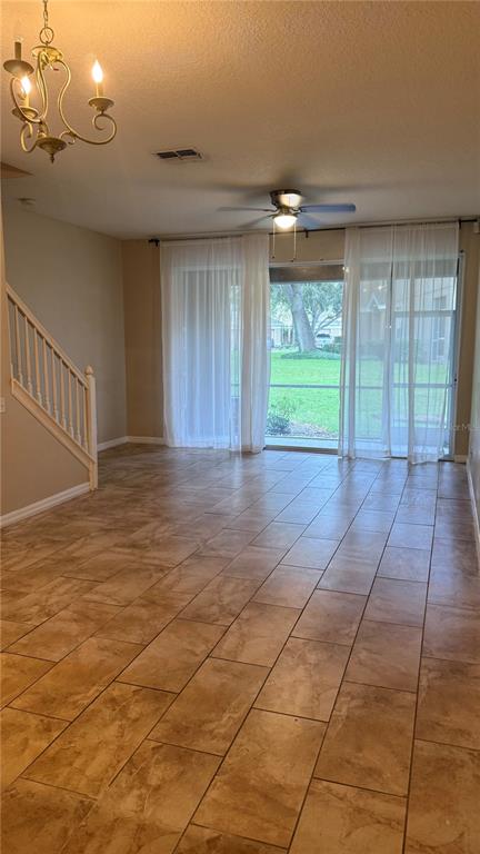 A living room features tile flooring, a ceiling fan, a chandelier, and sliding glass doors — 4135 BISMARCK PALM DRIVE, TAMPA, FL
