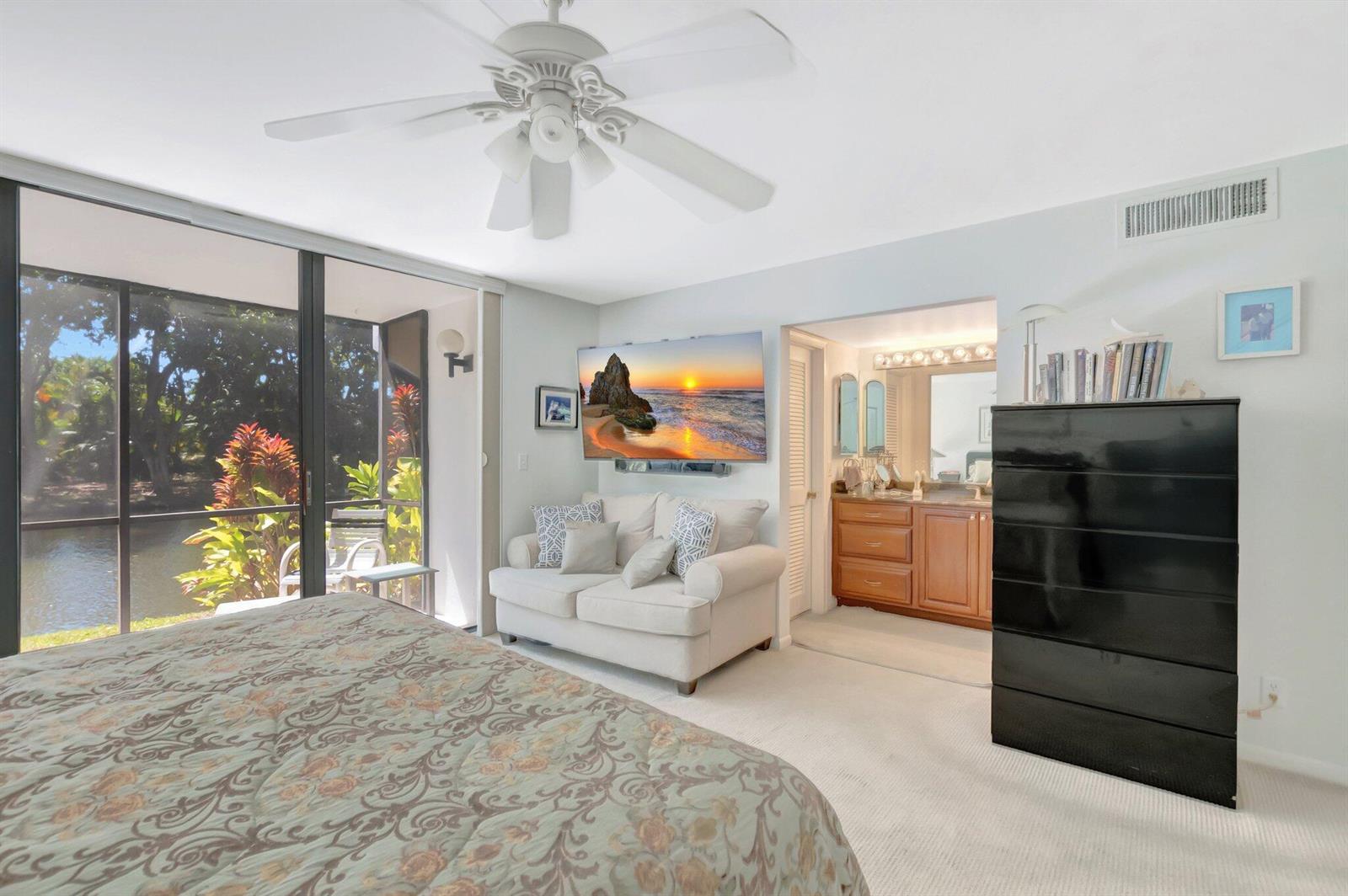 A bedroom features a bed, a loveseat, a television, a dresser, and a sliding glass door — 3705 Bridgewood Drive, Boca Raton FL 33434, BOCA RATON, FL