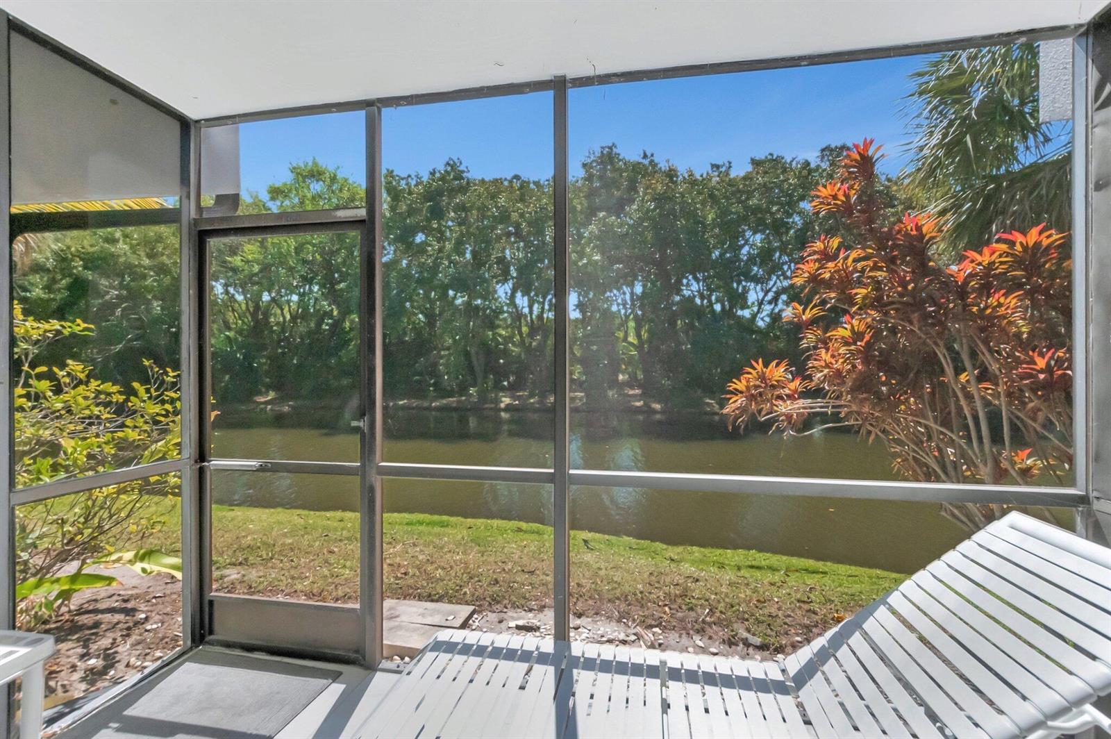 A screened-in porch overlooks a canal and lush green trees — 3705 Bridgewood Drive, Boca Raton FL 33434, BOCA RATON, FL