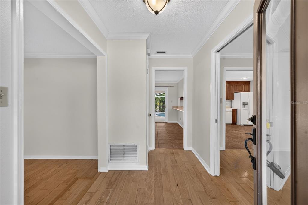 A view from an entryway looking into a hallway with wood flooring and a kitchen — 2051 DYAN WAY, MAITLAND, FL