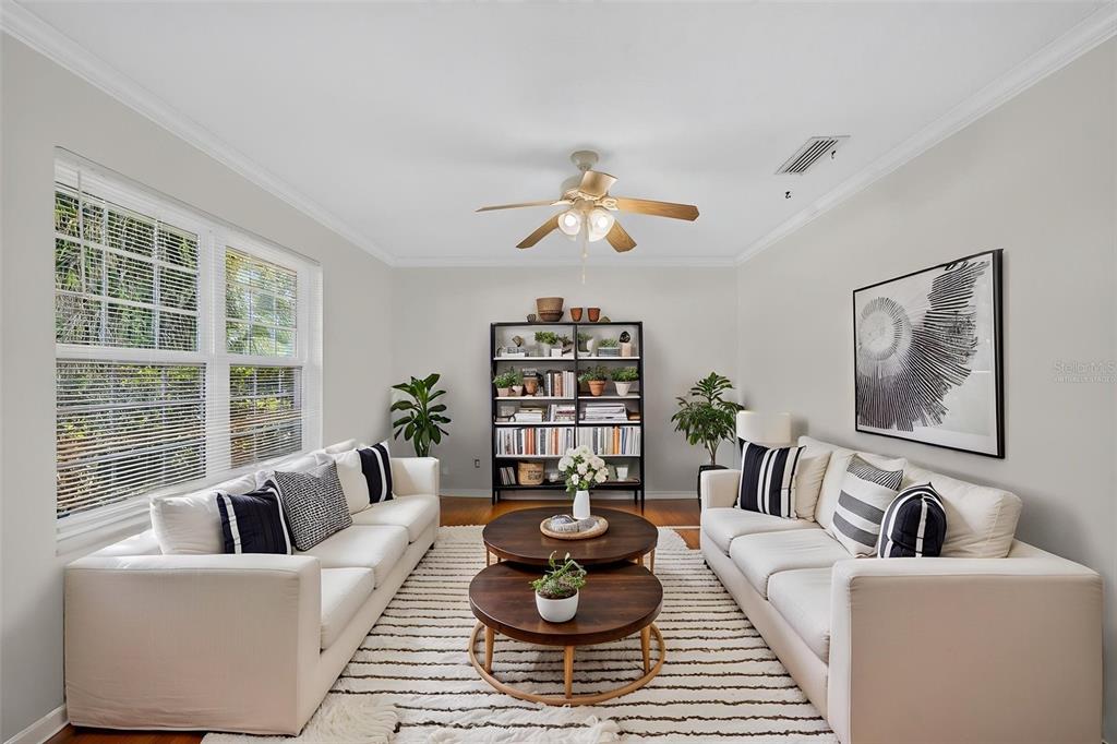 A living room features two white sofas, round wooden coffee tables, and a tall bookshelf — 2051 DYAN WAY, MAITLAND, FL