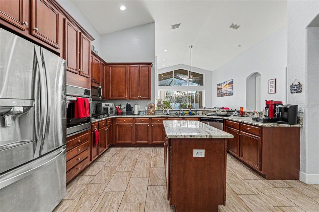 A dining area with a wooden table and chairs sits in front of a living room — 12515 BURGESS HILL DRIVE, RIVERVIEW, FL