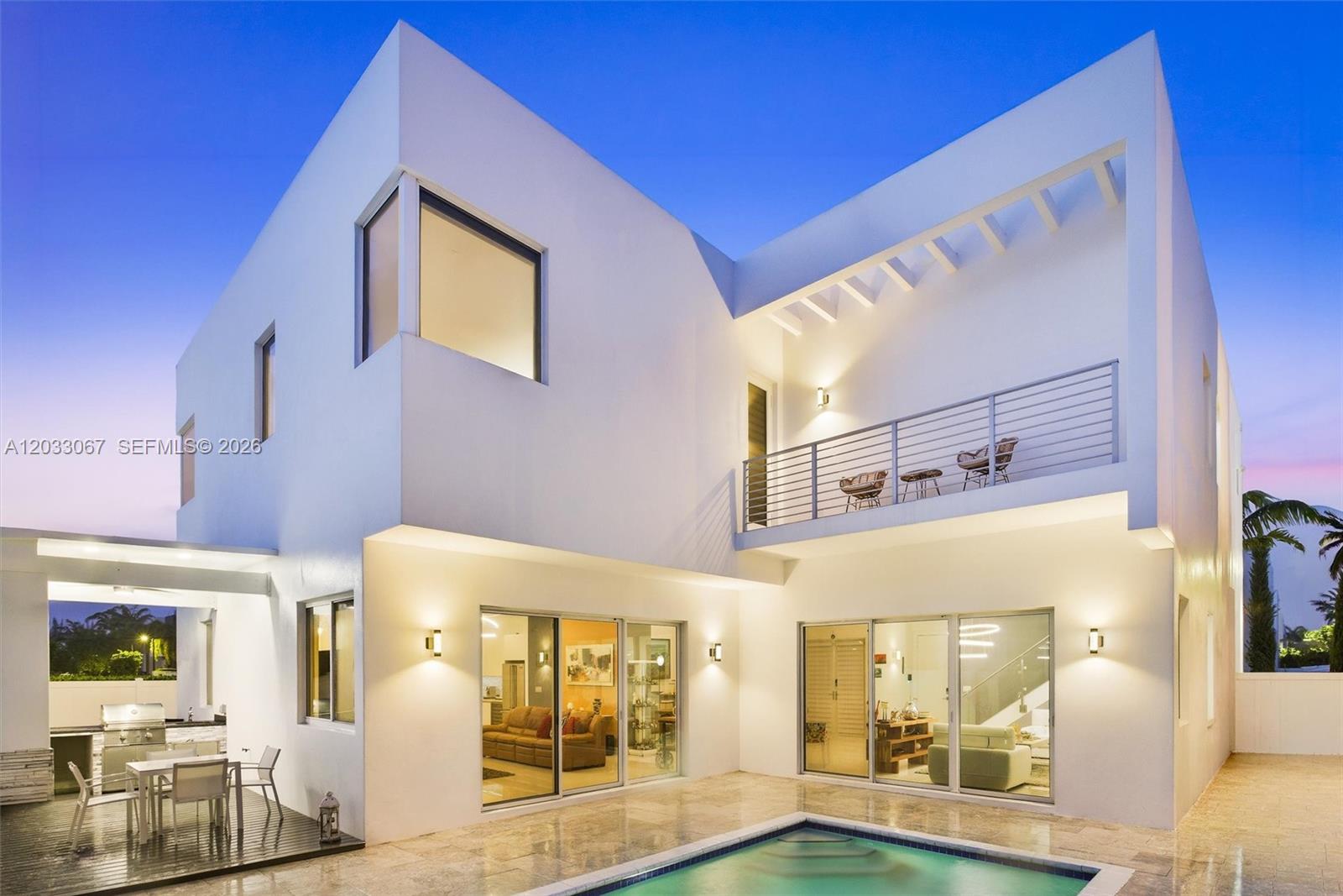 A modern two-story white house features a swimming pool, patio, and an upper-level balcony — 7472 NW 100th Ave, Doral FL 33178, DORAL, FL