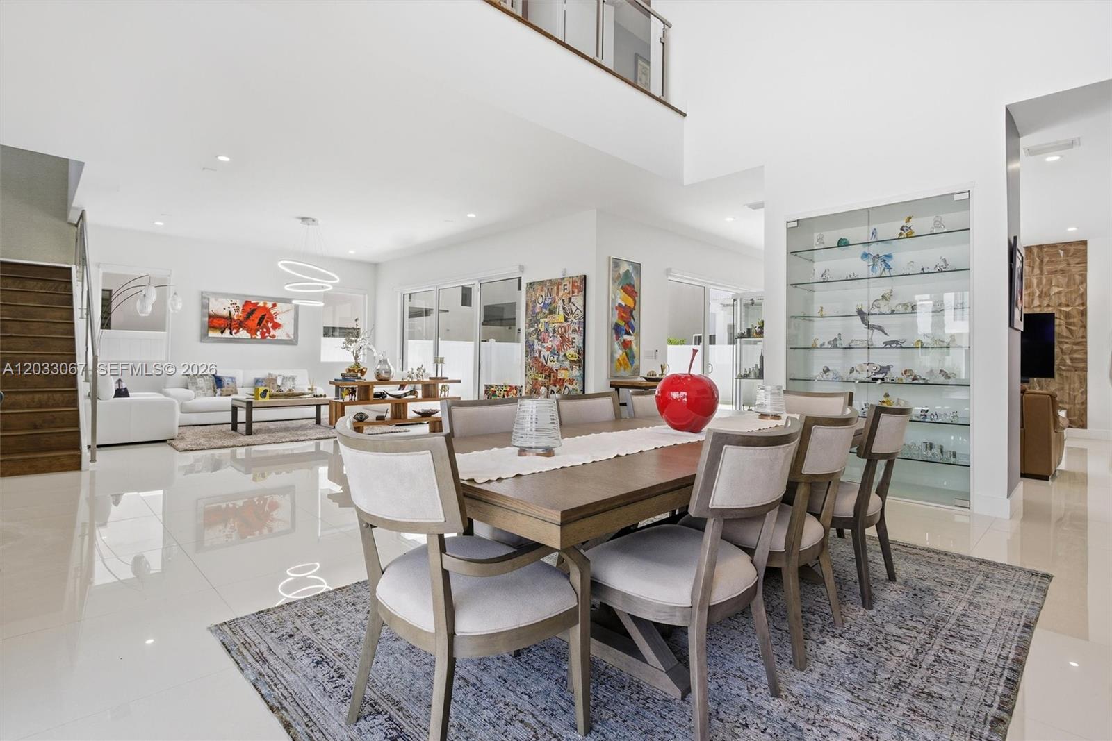 A dining area with a wooden table and chairs sits in an open-concept living space — 7472 NW 100th Ave, Doral FL 33178, DORAL, FL