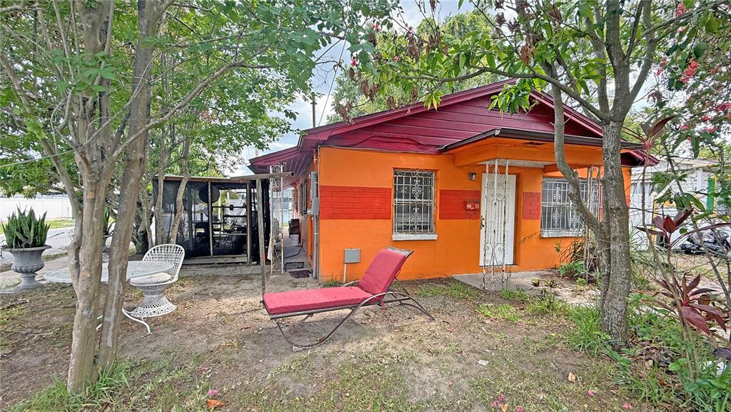 An orange house with a red roof and a red lounge chair in the yard — 3511 E 23RD AVENUE, TAMPA, FL