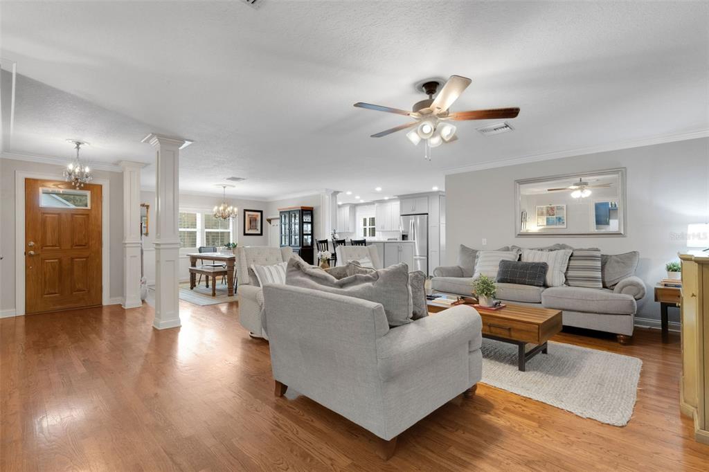 An open-concept living room features hardwood floors, a ceiling fan, and a neutral color palette — 2625 NEVADA ROAD, LAKELAND, FL