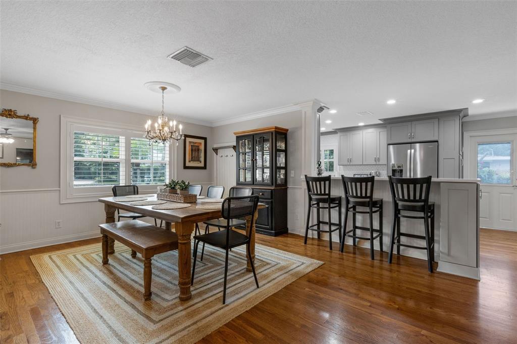A dining area with a wooden table and bench sits adjacent to a kitchen island — 2625 NEVADA ROAD, LAKELAND, FL