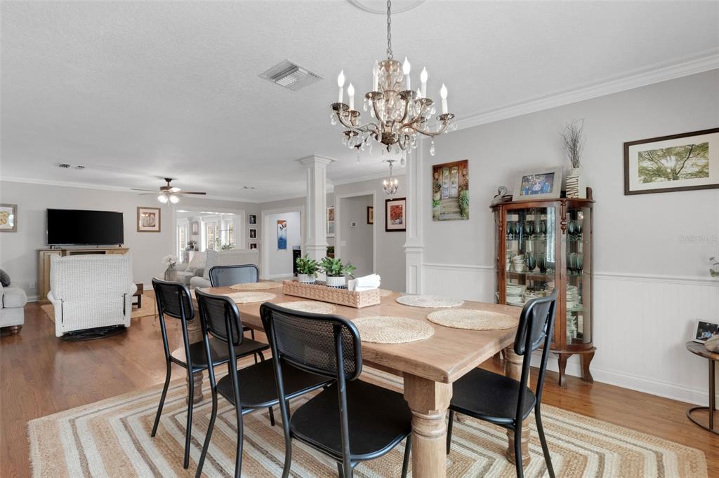 A dining room features a wooden table, black chairs, a crystal chandelier, and a hutch — 2625 NEVADA ROAD, LAKELAND, FL