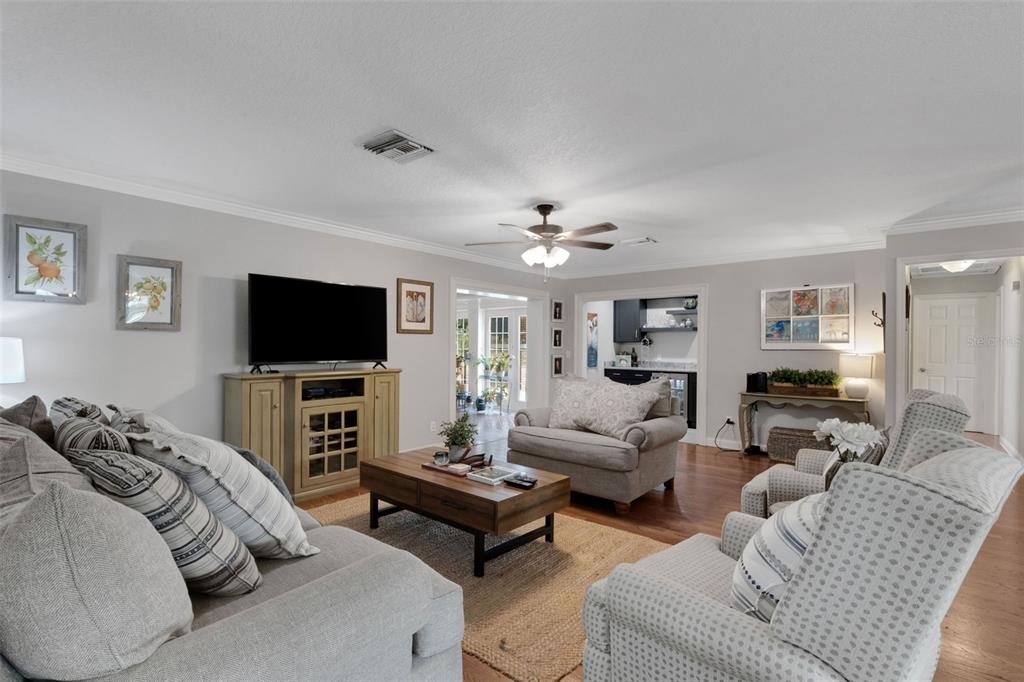 A living room features a television, gray sofas, a wooden coffee table, and hardwood floors — 2625 NEVADA ROAD, LAKELAND, FL