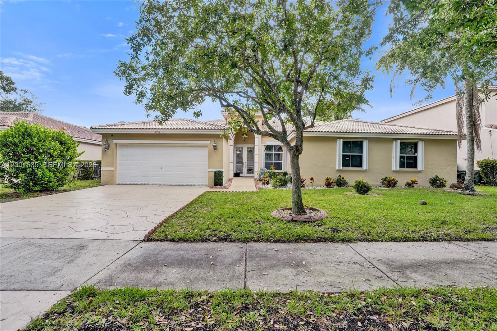 A single-story house with a beige stucco exterior, a tiled roof, and a paved driveway — 4286 NW 42nd Ter, Coconut Creek FL 33073, COCONUT CREEK, FL