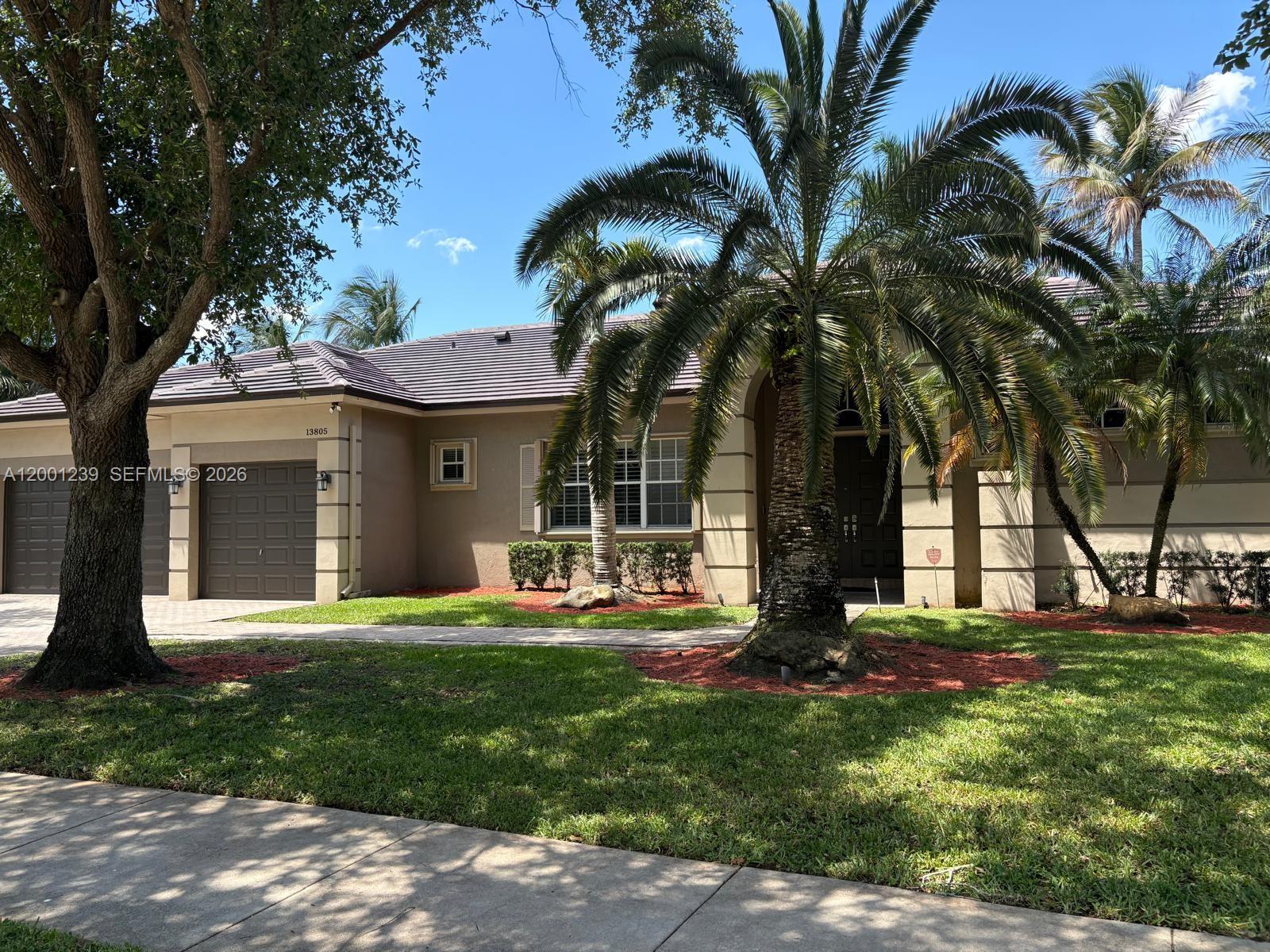 A single-story house with a brown garage, a large palm tree, and a tiled roof — 13805 SW 41st St, Davie FL 33330, DAVIE, FL