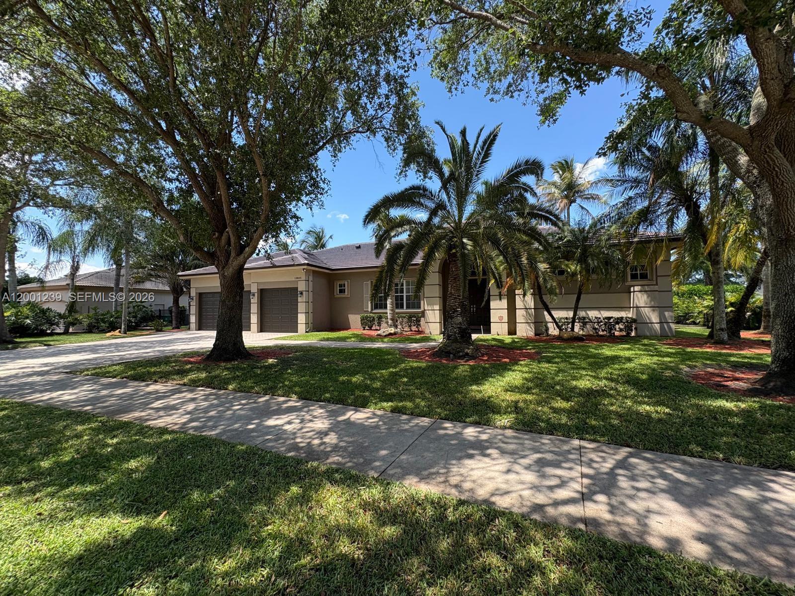 A single-story house with a two-car garage, palm trees, and a front lawn — 13805 SW 41st St, Davie FL 33330, DAVIE, FL