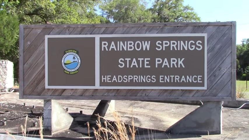 A wooden sign for Rainbow Springs State Park Headsprings Entrance stands outdoors in a grassy area — SW 207TH COURT, DUNNELLON, FL