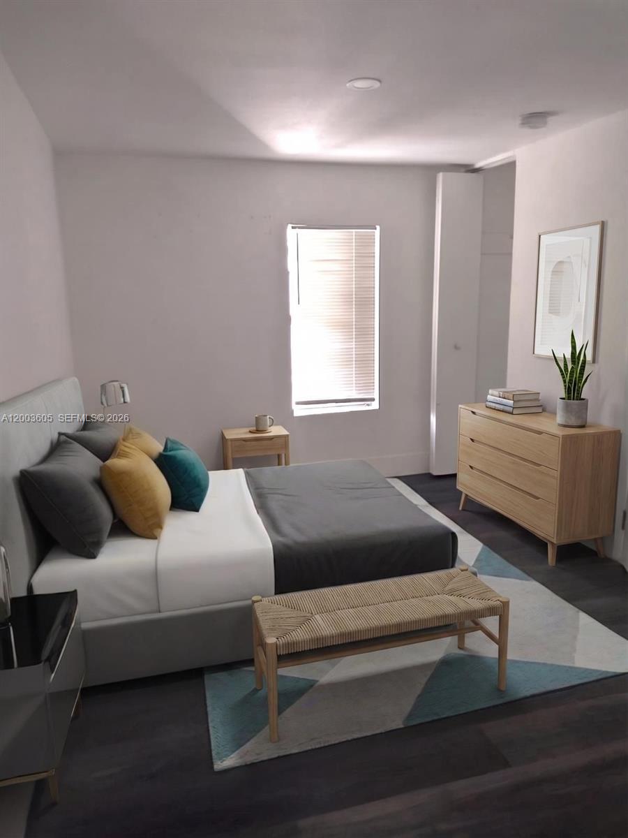 A bedroom features a gray bed, a wooden dresser, a woven bench, and a window — 2971 NW 132nd Ter # B, Opa-Locka FL 33054, OPA-LOCKA, FL