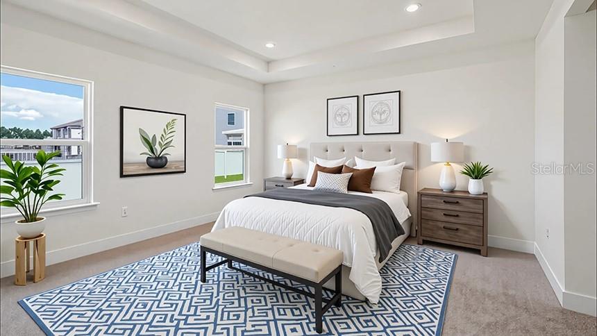 A bedroom features a bed with a patterned rug, two nightstands, and a tray ceiling — 4224 SW 52ND LANE ROAD, OCALA, FL