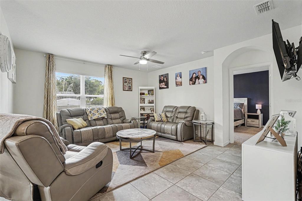 A single-story house with a beige stucco exterior, red shutters, and a two-car garage — 1718 PACE DR NW, PALM BAY, FL