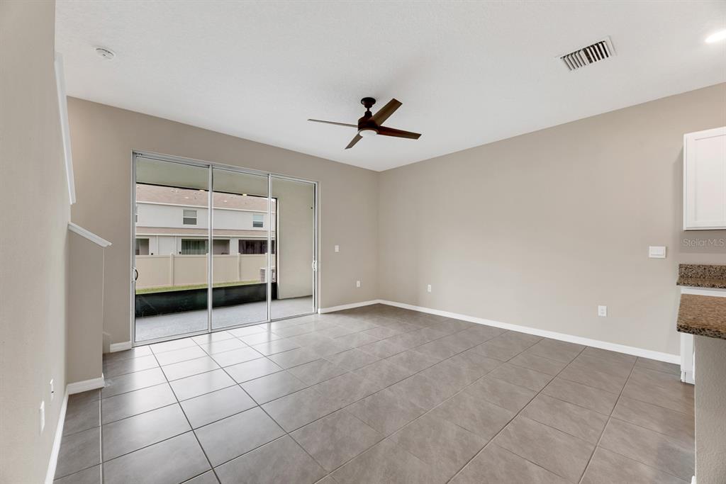 A living area with gray tile flooring, a ceiling fan, and sliding glass patio doors — 3507 MARIGOLD PATCH COURT, PLANT CITY, FL