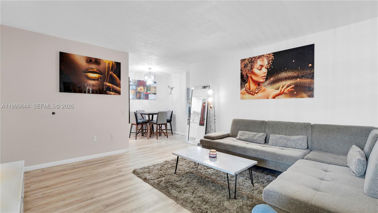 A living room features a gray sectional sofa, a marble coffee table, and wall art — 16900 NE 14th Ave # 204, Miami FL 33162, MIAMI, FL