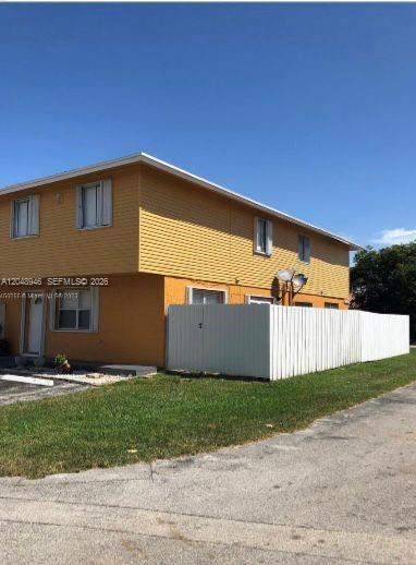 A two-story yellow apartment building with a white privacy fence and a paved driveway — 43 NE 12th Ave # 43, Homestead FL 33030, HOMESTEAD, FL