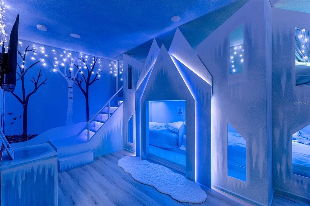 A themed bedroom features a custom ice castle bunk bed structure with blue LED lighting — 1406 WEXFORD WAY, DAVENPORT, FL