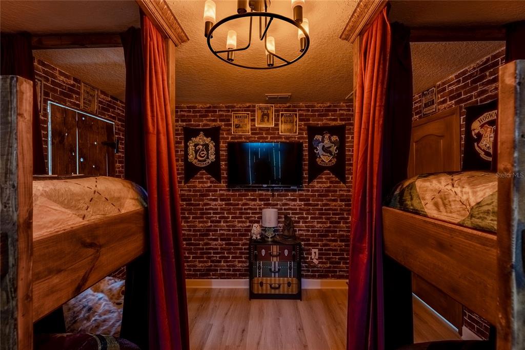 A Harry Potter-themed bedroom features bunk beds, brick-patterned wallpaper, and house banners — 1406 WEXFORD WAY, DAVENPORT, FL